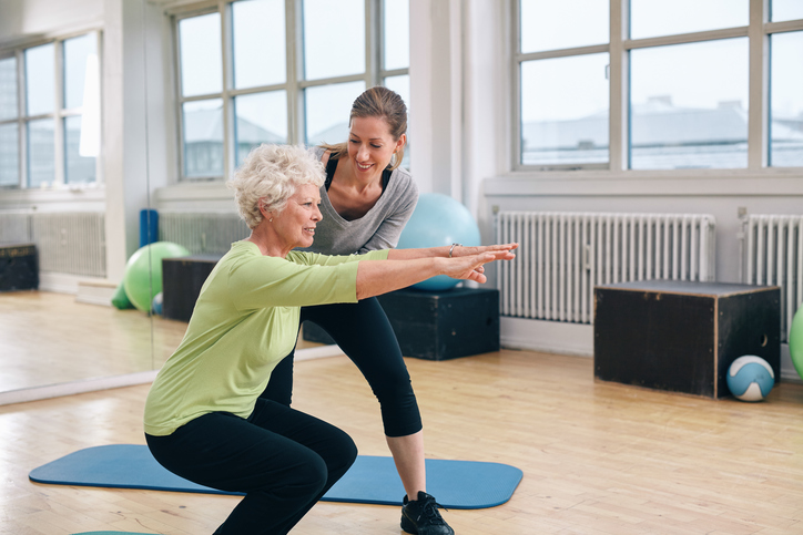 Trainer assisting a client with exercise
